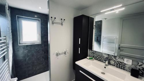 une salle de bain avec un lavabo et un miroir dans l'établissement Maison du petit moulin, à Soullans