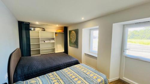 une petite chambre avec un lit et une fenêtre dans l'établissement Maison du petit moulin, à Soullans