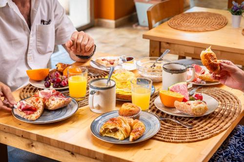 a table with plates of breakfast foods and orange juice at La Muntanya in Llafranc