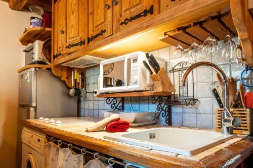 une cuisine avec un évier et un plan de travail dans l'établissement Appartement cosy au pied des pistes, à La Salle Les Alpes