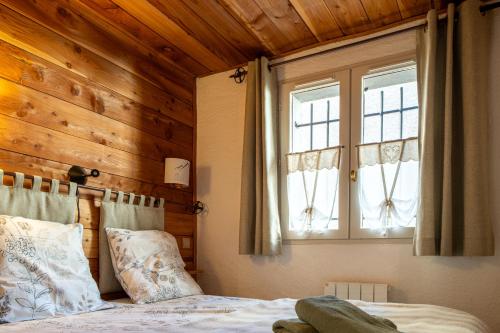 une chambre avec un lit et un mur en bois dans l'établissement Appartement cosy au pied des pistes, à La Salle Les Alpes