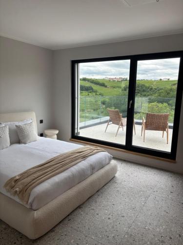 a bedroom with a bed and a large window at Vila Solini in Kozana