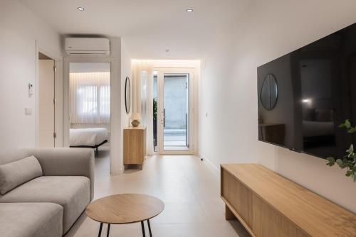 a living room with a couch and a tv on a wall at Loft América 41 A in Melide