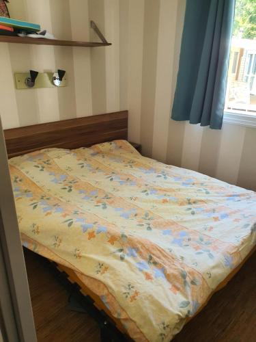 un lit avec une couette dessus dans une chambre dans l'établissement Mobile home, à Agde