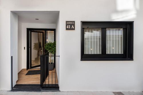 a white building with two windows and a doorway at Loft América 41 A in Melide