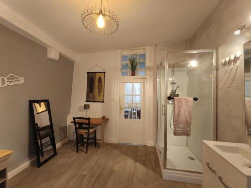 a bathroom with a shower and a sink and a table at Le Liberté appartement privatif in Saint-Léonard-de-Noblat