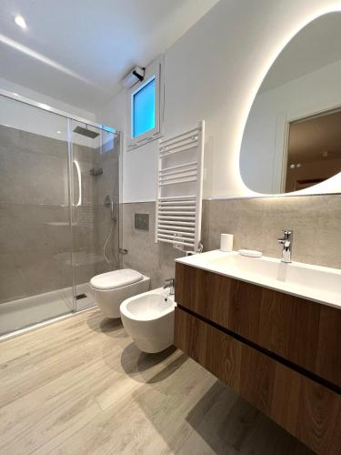 a bathroom with two sinks and a toilet and a shower at Appartamento Gocce di sole in Pietra Ligure