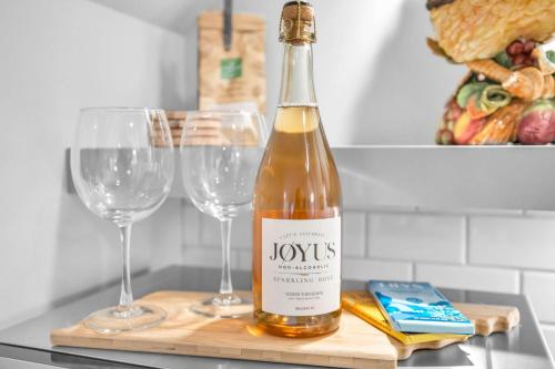 a bottle of wine on a cutting board with two wine glasses at Historic West End Guest Studio Suite by SkyRun Nashville in Nashville