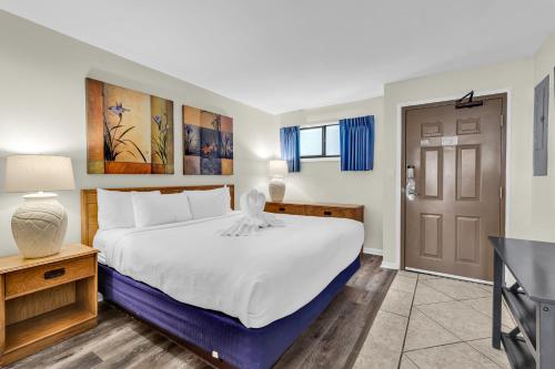 a bedroom with a large white bed and a table at Spectacular Oceanview Condos in Myrtle Beach