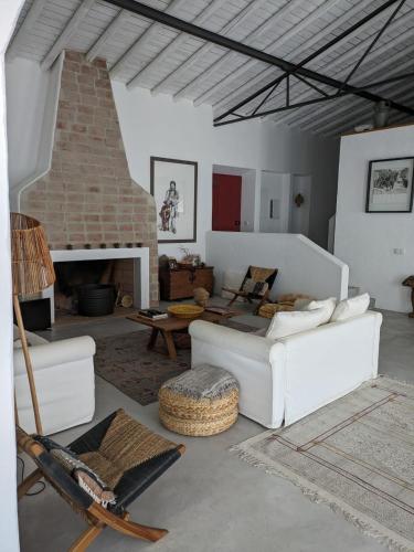 a living room with white furniture and a fireplace at Casa do Tanque in Serpa