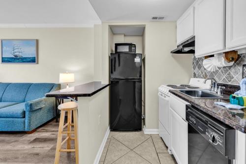 a kitchen with a black refrigerator and a sink at Spectacular Oceanview Condos in Myrtle Beach