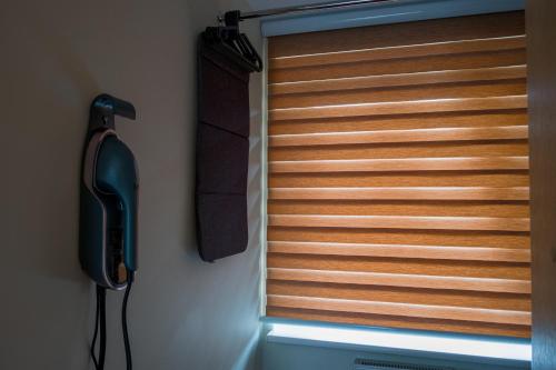 a window with wooden blinds in a room at Agneta Apartamentai in Druskininkai