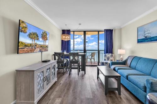 a living room with a blue couch and a table at Spectacular Oceanview Condos in Myrtle Beach