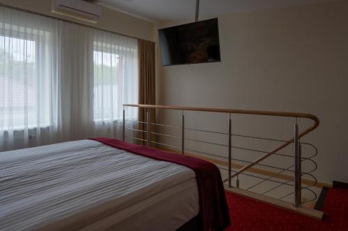 a bedroom with a bed with a railing and a window at Agneta Apartamentai in Druskininkai