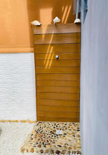 a wooden door with a pebble floor in a room at Pousada Brunetti in Penha