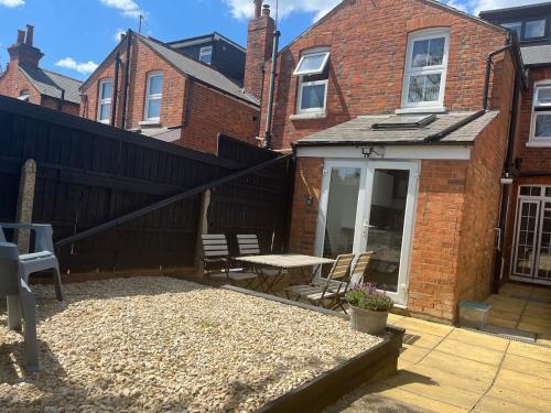 a patio with a table and chairs in front of a building at Westfield Town-House Free Parking, Secure Garden in Caversham