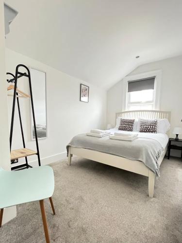 a white bedroom with a bed and a ladder at Westfield Town-House Free Parking, Secure Garden in Caversham