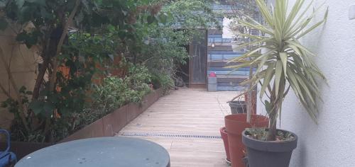 a patio with plants and a table and a hallway at Jardin de plantes centre-ville résidential Botanical garden residential down-town in Le Mans