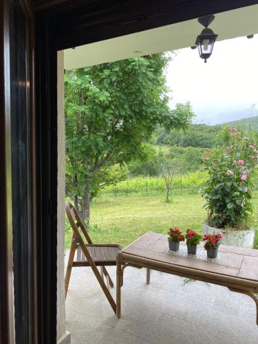 a table and a chair on a porch with flowers at Rizospito in Palaiokhóra