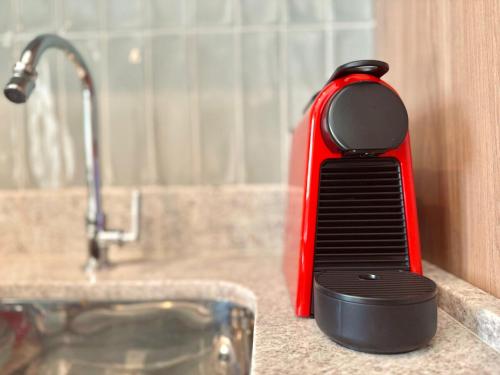 a red and black comb sitting on a counter next to a sink at 1512 - Rentaqui Studio Lux Modernidade Santo Amaro in Sao Paulo