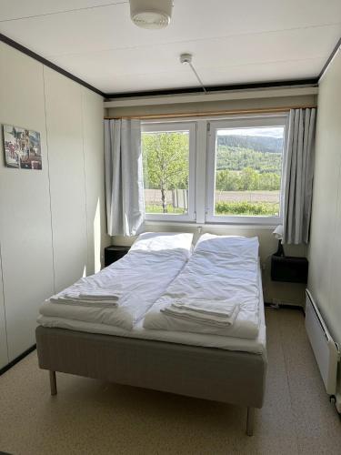 a bed in a room with a large window at Karivollen Overnatting in Melhus