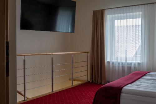a bedroom with a bed and a window at Agneta Apartamentai in Druskininkai