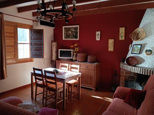 a kitchen with a table and chairs in a room at La Atalaya de Los Romanes in Viñuela