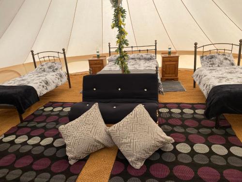 a room with three beds and a rug at Hendre Glamping Retreat- The Sparrow's Nest in Clydey