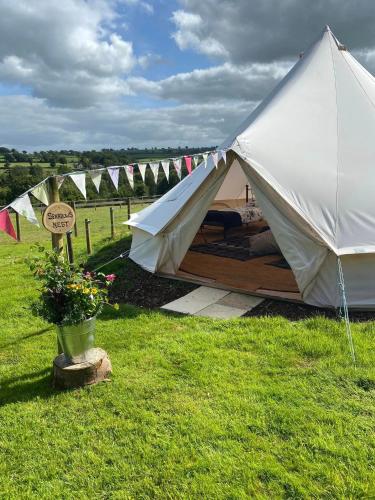 a large white tent in a field with a sign at Hendre Glamping Retreat- The Sparrow's Nest in Clydey