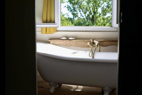 une baignoire dans une salle de bain avec une fenêtre dans l'établissement Château du Grand Hamel, à Mesnil-Raoul