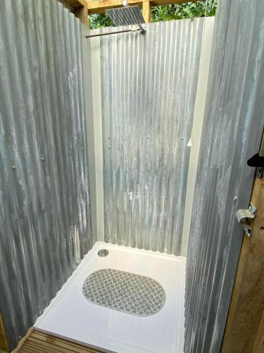 a bathroom with a shower with a shower curtain at Hendre Glamping Retreat- The Sparrow's Nest in Clydey