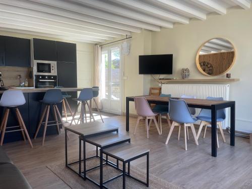 une cuisine et un salon avec une table et des chaises dans l'établissement Horizon Bois by Melrose, à Asnelles