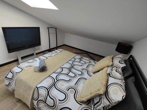 a bedroom with a large bed and a flat screen tv at Villa Atlantica Torreira Piscine Salle de Jeux in Torreira