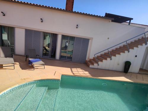a swimming pool in front of a house at Villa Atlantica Torreira Piscine Salle de Jeux in Torreira