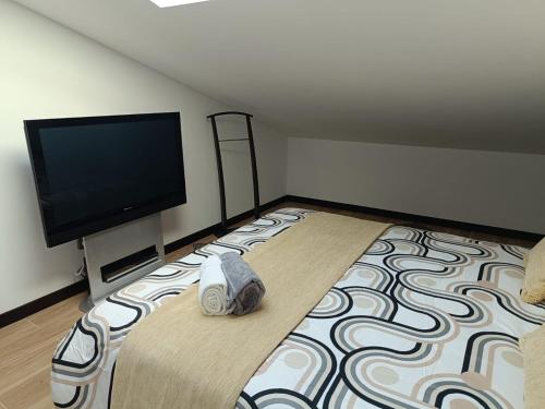 a bedroom with a large bed with a flat screen tv at Villa Atlantica Torreira Piscine Salle de Jeux in Torreira