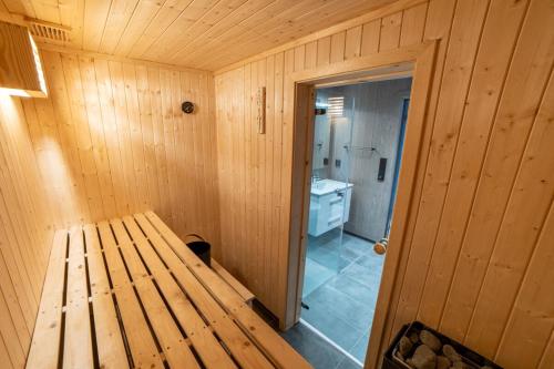Una cabaña de madera con un banco en un baño. en Sunnmøre Getaway, en Sykkylven