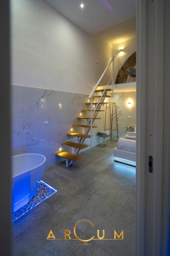 a bathroom with a staircase and a tub and a bed at ARCUM suites in Palermo