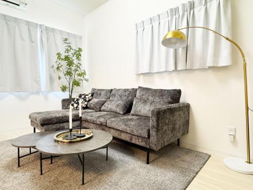 a living room with a couch and a table at Otter Stay - Masaki in Nagoya