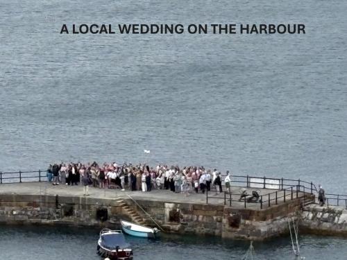 a group of people standing on a pier next to the water at What a view Mevagissey in Mevagissey