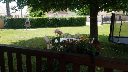 a garden with chairs and flowers on a fence at Chalet du Tilleul in Poncey-lès-Athée