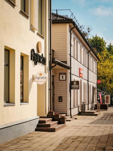 a building with a sign on the side of it at Agneta Apartamentai in Druskininkai