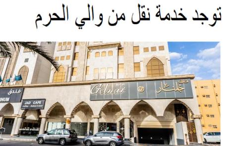 a building with arabic writing on it with cars parked outside at فندق جلنار الراقي للايواء السياحي in Al Madinah