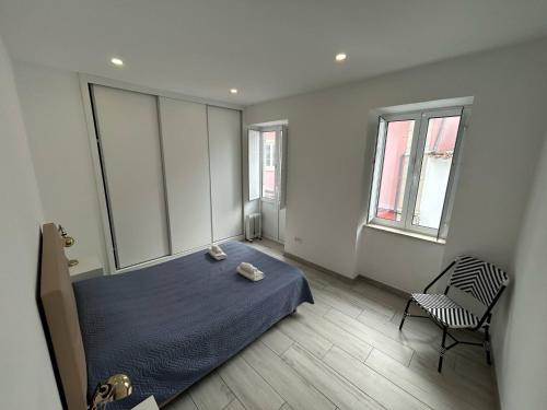 a bedroom with a bed and a chair in it at Casa Jonhy in Faro