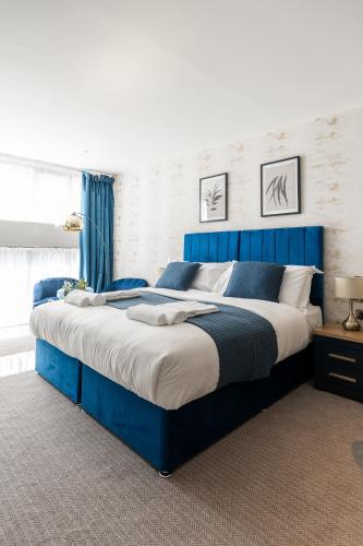 a large blue bed in a bedroom with blue curtains at Above Hotels in Burnley