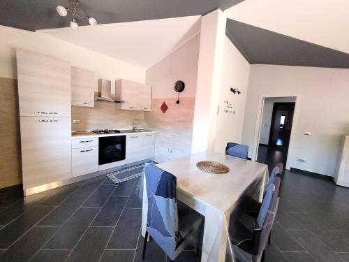 a kitchen with a table and chairs in a room at House Sa Sedda in Carbonia