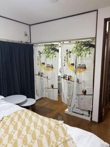 ein Schlafzimmer mit einem Bett und Vorhängen mit Früchten darauf in der Unterkunft Yui HOSTEL in Tokio