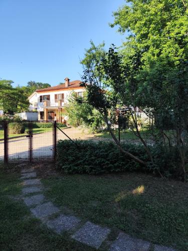 a fence in front of a house with a tree at La Crota in Asti