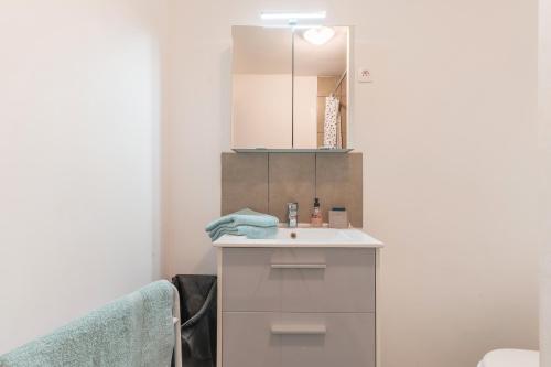une salle de bain avec un lavabo et un miroir dans l'établissement Au pied de la Sainte Victoire, à Puyloubier