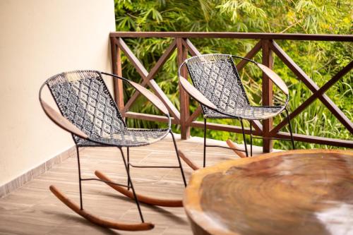 two chairs and a wooden table on a balcony at Portales del Tayrona Garden Hotel in Calabazo