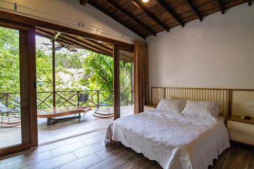 a bedroom with a bed and a balcony at Portales del Tayrona Garden Hotel in Calabazo